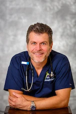 Joseph Gauta MD in navy scrubs with stethoscope